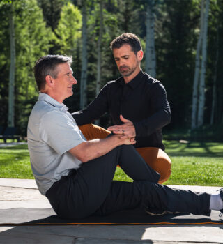 man with his trainer helping to stretch his glutes fitforever online personalized fitness programs